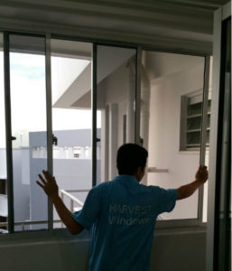Worker installing window for high rise service yard